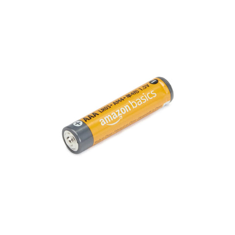 Close-up of a single AAA alkaline battery, labeled Amazon Basics, showing 1.5V, part of a 12 pack with 10 year shelf life, for home use.