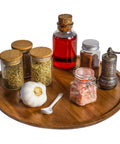 Acacia wood lazy susan organizer designed for kitchen and pantry use, displaying spices, oils, and garlic.