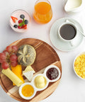 Breakfast setup with Acacia Wood Lazy Susan Turntable Organizer 8-Inch Round Rotating Serving Tray holding cheese, bread, and jam.