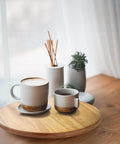 18 inch acacia wood lazy susan cabinet organizer with coffee cups and decorative vases on a wooden table.