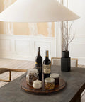 18-Inch Acacia Wood Lazy Susan Turntable with Metal Frame on dining table, featuring jars and wine bottles, for charcuterie and cheese board setup.