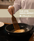Person using Spurtle Kitchen Tools Wooden Set For Nonstick Cookware to stir food in a pan, showcasing heat resistance and non-scratch qualities.