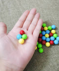 Hand holding 60Pcs Game Replacement Marbles Balls Compatible with Hungry Hungry Hippos, acrylic, colorful, 13.5mm diameter.