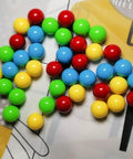 60Pcs Game Replacement Marbles Balls Compatible with Hungry Hungry Hippos in red, yellow, blue, green on patterned surface