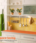 Adhesive Kitchen Hooks Utensil Hanger Holder Hanging Rack 2 Pack with spoons and cups on wall-mounted kitchen rail against yellow tile backsplash