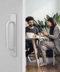 Adhesive Cabinet Handles 2 Pack 5.8 Inch No Drill Push Pull Self Stick Installation silver handle on a door with people dining in background.