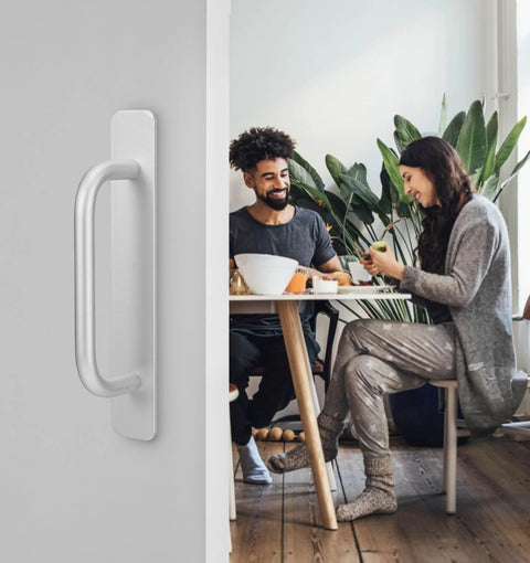 Adhesive Cabinet Handles 2 Pack 5.8 Inch No Drill Push Pull Self Stick Installation silver handle on a door with people dining in background.