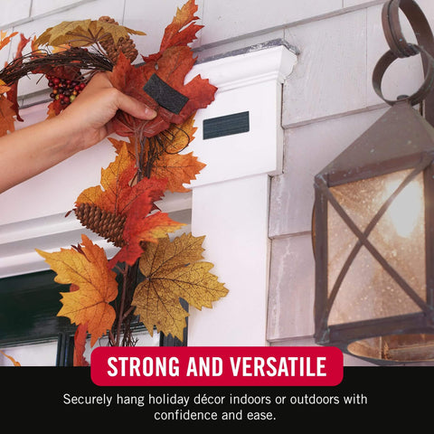 Heavy Duty No Nail Stick On Adhesive Strips For Hassle Free Quick Mounting Indoor Outdoor Use 4 Inch By 2 Inch 2 Pack Holds Up To 10 Lbs On Smooth Surfaces Great For Plastic Metal Painted Wallboard being used to hang autumn decorations on a white door frame.