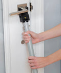 Person installing Adjustable Door Security Bar With Vibration Detecting Alarm And 115 Decibel Siren That Emits Up To 1100 Feet