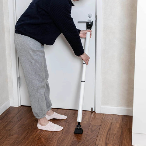 Person installing Door Security Bar Adjustable Door Stoppers Sliding Glass Door Security Bar 2 in 1 Heavy Duty Door Jammer for Home