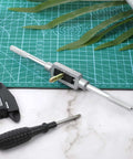 Adjustable Tap Wrench Handle M3 To M12 With 1/16 To 1/2 Inch Capacity For Pros And DIYers on a green cutting mat with tools