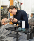Barber using On Wheels Salon Tray Cart With Adjustable Height And Storage Platform Aluminum And Iron Rolling Tray for grooming.