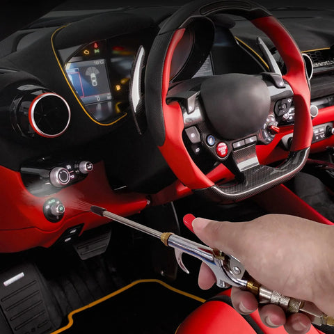 Hand using 13-Piece 2-Way Air Nozzle Kit with Quick Connects inside red car interior for efficient cleaning.