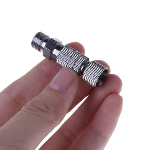Person holding Fast Swap Quick Release Airbrush Coupler Kit With One Eighth Inch BSP Male And Female Adapters in hand.