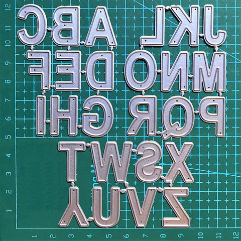 26 Capital Alphabet Dies Set For Metal Cutting, Card Making, Scrapbooking And DIY Embossing Projects on green grid