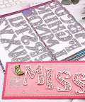 26 Piece Alphabet Letter Metal Cutting Dies For Scrapbooking Card Making And Paper Crafts Dope Die Cuts Vintage 5 cm Height High Quality Steel Die Cut Set From Alinacutle displayed on scrapbook with pink card saying 'MISS', showcasing intricate letter designs.
