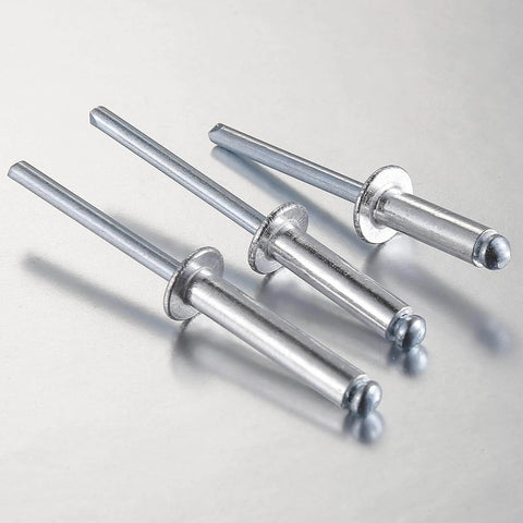 Close-up of three 250 Pack Aluminum Blind Rivets Three Sixteenths By One Half Inch With Aluminum Grip And Steel Mandrel on metal surface.