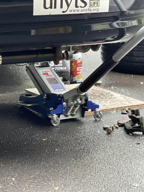 ✝️ 3000 Lb Aluminum Racing Car Auto Floor Jack Low Profile Rapid Pump Lift in use under vehicle with tools and lubricant nearby