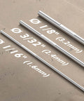 Different sizes of welding rods on concrete surface, highlighting ER4043 Aluminum TIG Welding Rod One Eighth Inch Diameter By Sixteen Inch Length Five Pound Pack For A Stable Arc With Low Spatter And Great Fluidity From High Silicon Content Welds Smooth With Argon Or Argon Helium Gas Pro Grade For Easy Aluminum Welds.