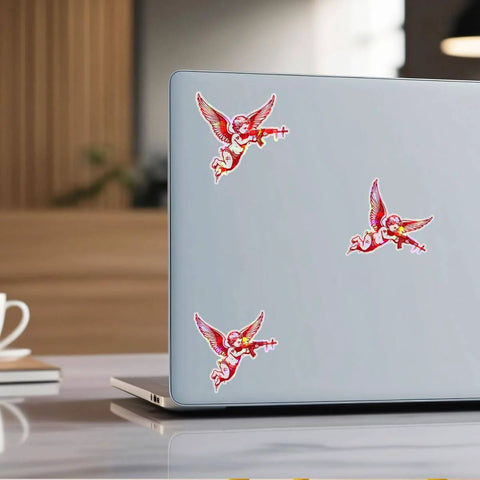 Set Of 3 Angel With Machine Gun Stickers on a laptop, 3 inch vinyl decals for personalizing water bottles, laptops, phones, cars, helmets, windows.
