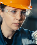 Woman wearing clear safety glasses and hard hat for protection, Clear Safety Glasses 24 Pack ANSI Z87.1 Impact Resistant Eye Protection UV400