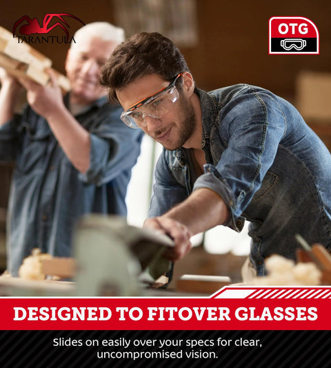 Man wearing ANSI Z87.1 Safety Glasses For Over Eyeglasses With Anti Scratch Lenses, in workshop environment, focused on a task.