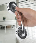 Hand holding Anti Slip Vacuum Suction Cup Handrail for bathroom and kitchen on glass door, chrome ABS PC grab bar handle, no sweat install.