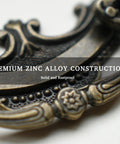 Close-up of Antique Brass Baroque Style Drop Bail Drawer Pull with ornate curves and floral accents in zinc alloy construction.