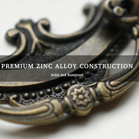 Close-up of Antique Brass Baroque Style Drop Bail Drawer Pull with ornate curves and floral accents in zinc alloy construction.