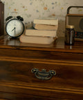 Antique Brass Baroque Style Drop Bail Drawer Pulls 8 Pack with 2 Inch Hole Centers, ornate curves and floral accents on wooden dresser.