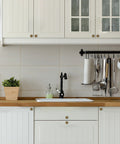 Antique Brass Cabinet Knobs 10 Pack For Kitchen Cabinets And Drawers installed in white kitchen shown on cabinet doors