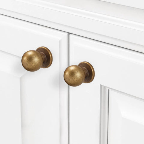Two Pack Antique Brass Kitchen Cabinet Knobs and Vintage Drawer Knobs in Aged Bronze Zinc Alloy Hardware installed on white cabinet
