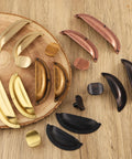 Assorted cabinet knobs and pulls on a wooden surface, showcasing various styles and finishes for kitchen and bathroom cabinets.