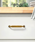 Six Pack Antique Brass Cabinet Pulls With 3 3/4 Inch Center To Center installed on white drawer in kitchen setting