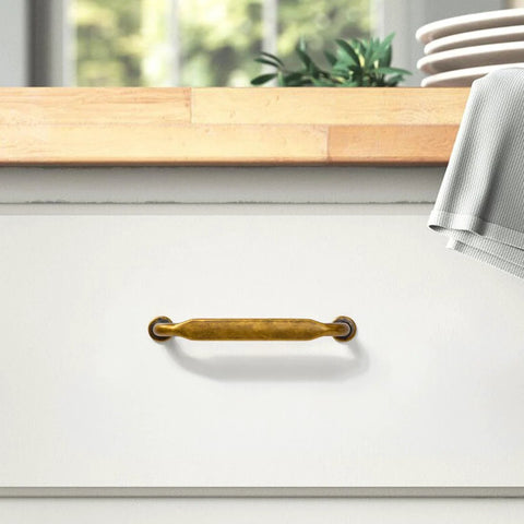 Six Pack Antique Brass Cabinet Pulls With 3 3/4 Inch Center To Center installed on white drawer in kitchen setting