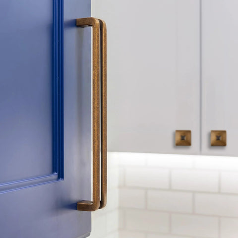 Antique Brass 5 Inch Hole Center Heavy Duty Solid Cabinet Pull on a blue kitchen cupboard, showcasing vintage style and zinc alloy durability