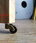 1 Inch Swivel Stem Ball Caster Wheel Zinc Alloy Antique Brass with wooden leg on floor