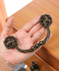 4-Pack Antique Brass Drawer Pulls 4.5 Inch Center-to-Center Drop Bail Dresser Handles Vintage Style Bronze Look Hardware shown in hand