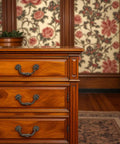 Wooden dresser with vintage style 4-Pack Antique Brass Drawer Pulls 4.5 Inch Center-to-Center Drop Bail Handles, ornate design