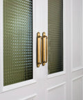 Antique Brass Drawer Pulls With Backplate Center To Center Five Point Zero Four Inches Zinc Alloy Cabinet Hardware installed on glass paneled doors.