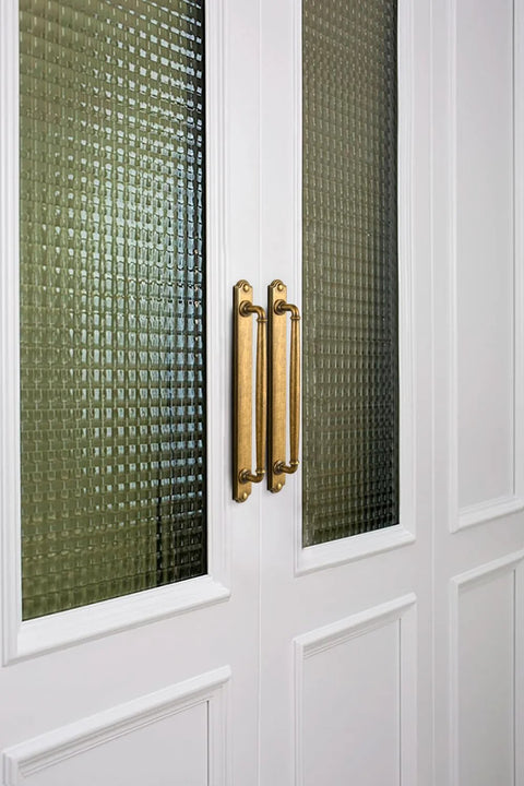 Antique Brass Drawer Pulls With Backplate Center To Center Five Point Zero Four Inches Zinc Alloy Cabinet Hardware installed on glass paneled doors.