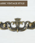 Antique Brass Drop Bail Drawer Pulls Six Pack With Two And A Half Inch Hole Centers, decorative furniture hardware close-up.