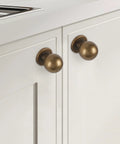 Antique Brass Kitchen Cabinet Knobs Set Of 10 For Solid Wood And Metal Drawers shown installed on white cabinet doors