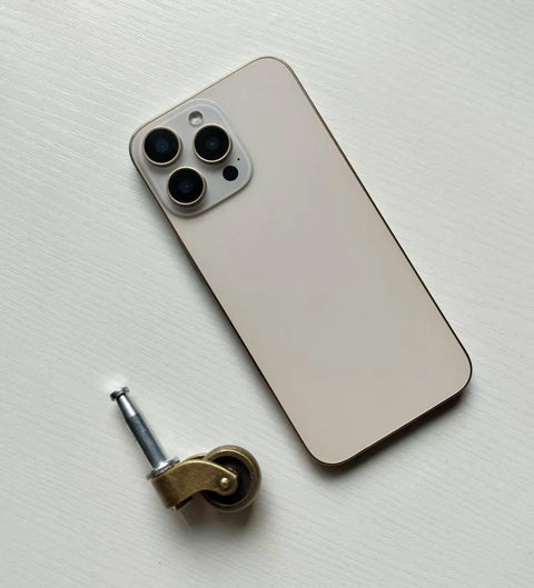 1 Inch Swivel Stem Ball Caster Wheel Zinc Alloy Antique Brass with Socket Mount 353 lb Capacity next to a smartphone