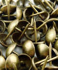 Antique brass upholstery tacks secure fabric, leather, and trim to wood frames and panels with a durable, decorative finish