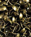 Close-up of antique brass upholstery tacks, 100 pcs per box, with 7/16 inch head and 1/2 inch shank for securing fabric and trim.