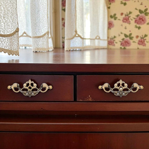 Wooden dresser with 4 Pack 3.25 Inch Center To Center Antique Bronze Bail Drawer Pulls, vintage style, in a rustic room setting.