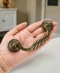 Hand holding antique bronze drawer pull, 4.5 Inch Center To Center Antique Bronze Drawer Pulls Pack Of 4 Bail Drop Swing Handles