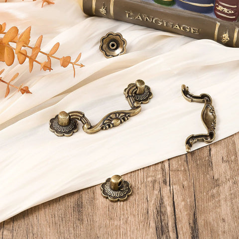 Antique Bronze Drawer Pulls Set With Screws Rustic Vintage Drop Handles on white fabric, showing decorative details, perfect for cabinets and furniture