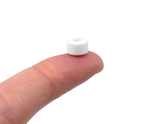 Single white wheel from New Street Style Apex Fingerboard Wheels With 71D Urethane, 7.7mm Diameter And Ultra Spin Bearings, Made In USA, on fingertip